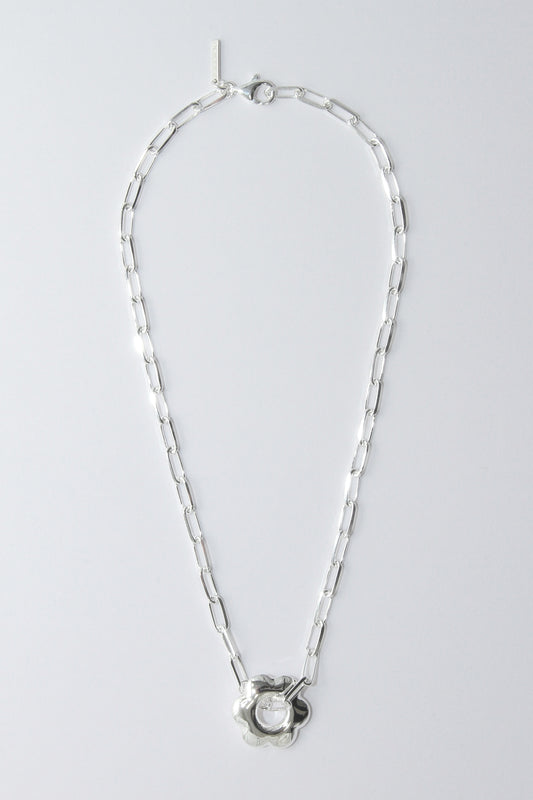 Silver necklace with a puffy, flower pendant on a light gray background