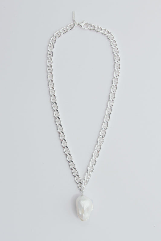 Chunky silver necklace with a large baroque pearl pendant.
