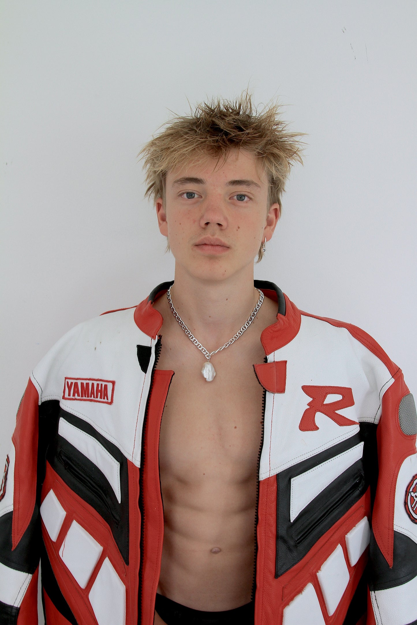 Man wearing large baroque pearl pendant on a chunky silver chain