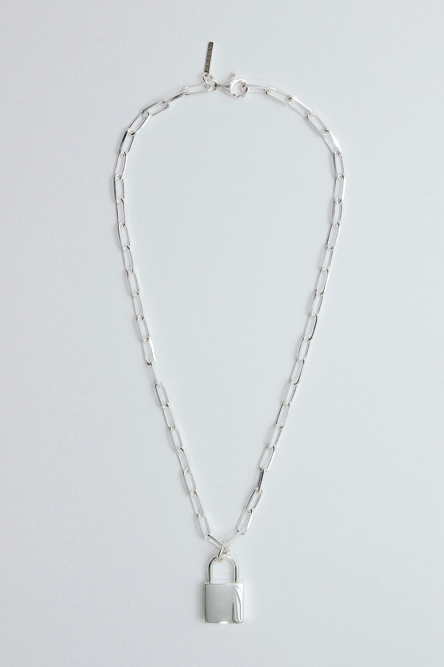 Silver chain necklace with a padlock pendant on a light gray background