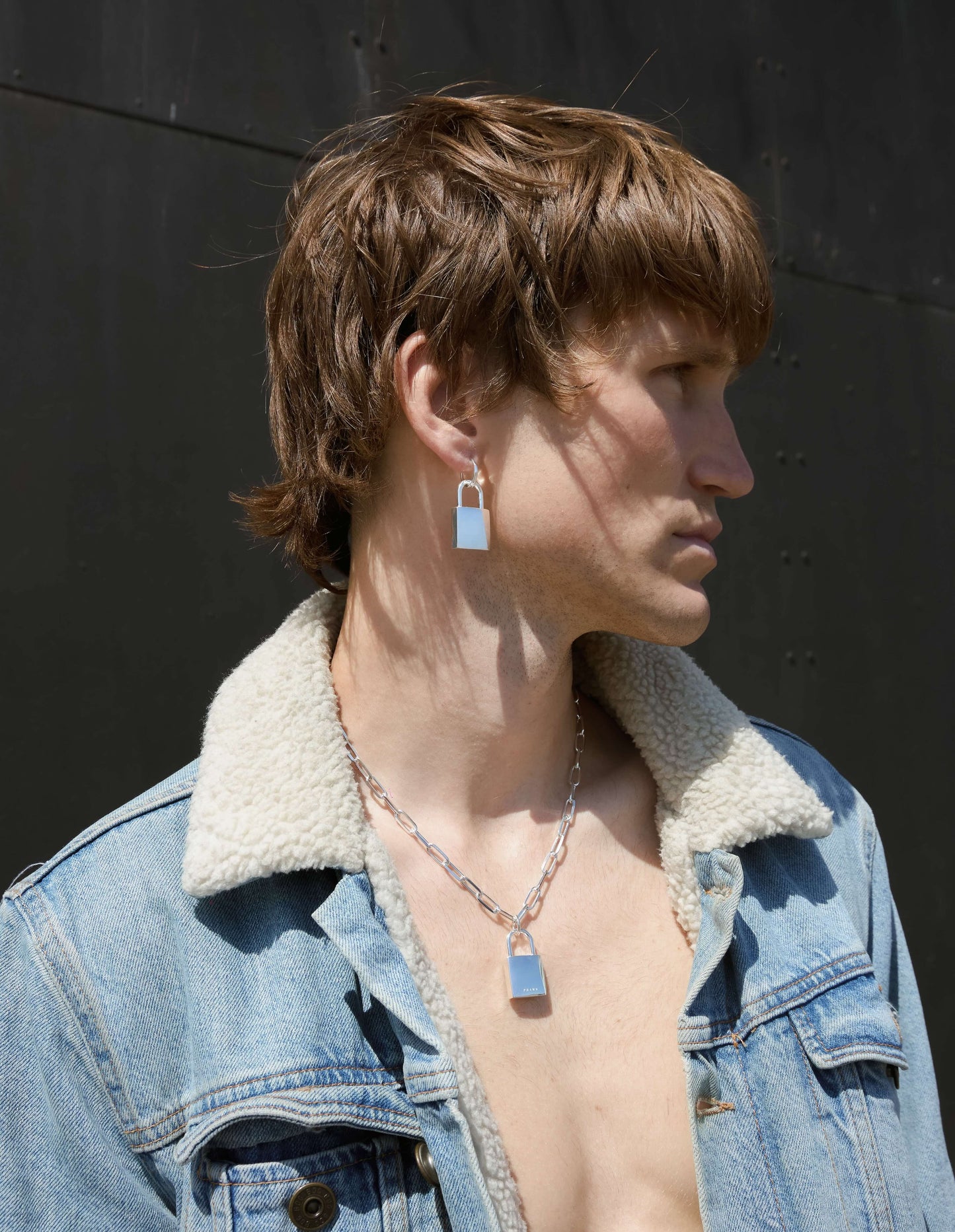 Silver padlock hoop earring worn by a man
