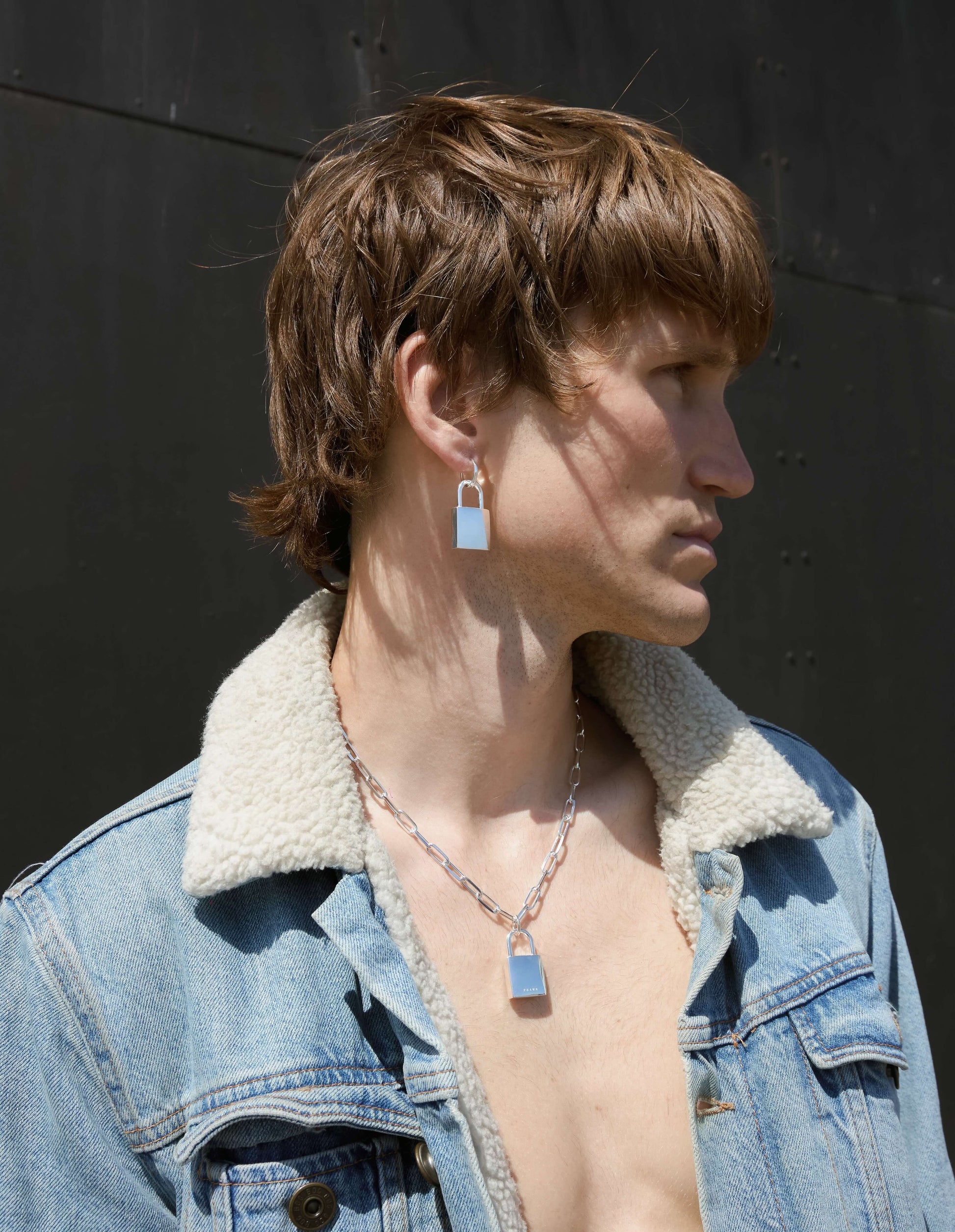 Silver padlock hoop earring worn by a man
